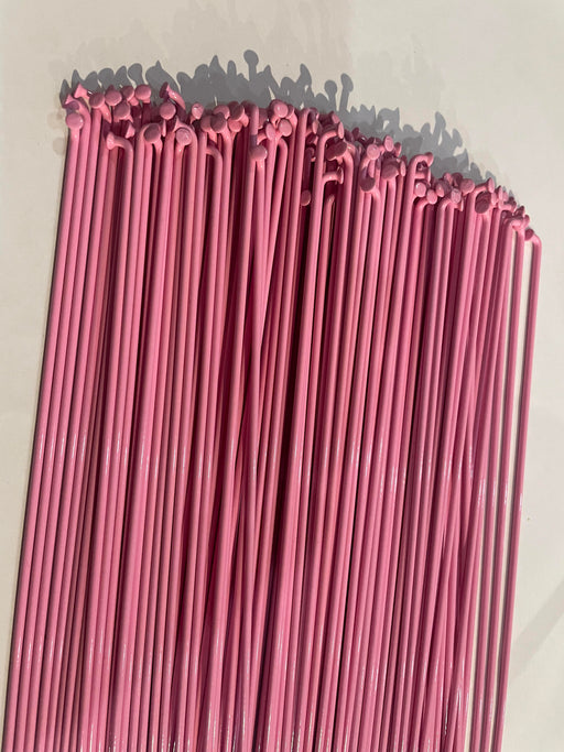 side view of stacked stainless steel spokes in pink