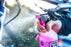 Person cleaning a bicycle with a pink muc off ultimate bike cleaning spray bottle, bike cleaning accessories