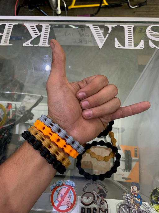 Complete view of the Stacked Chain Wrist bands in black, brown, orange, grey
